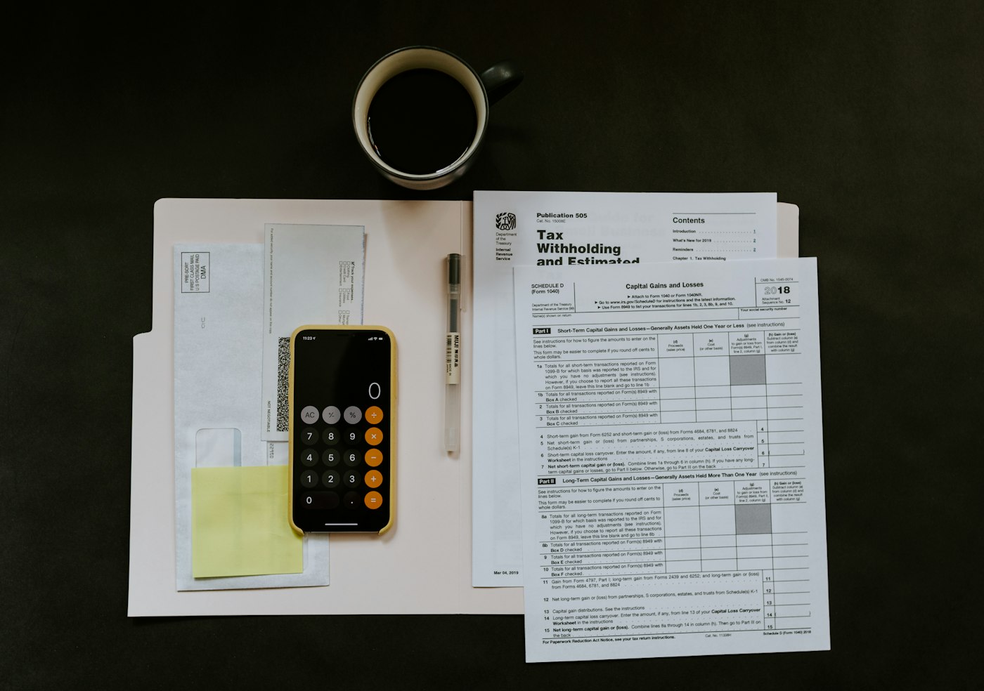 Open monthly budget planner beside a calculator, expense tracker, savings goal, and tablet spending overview
